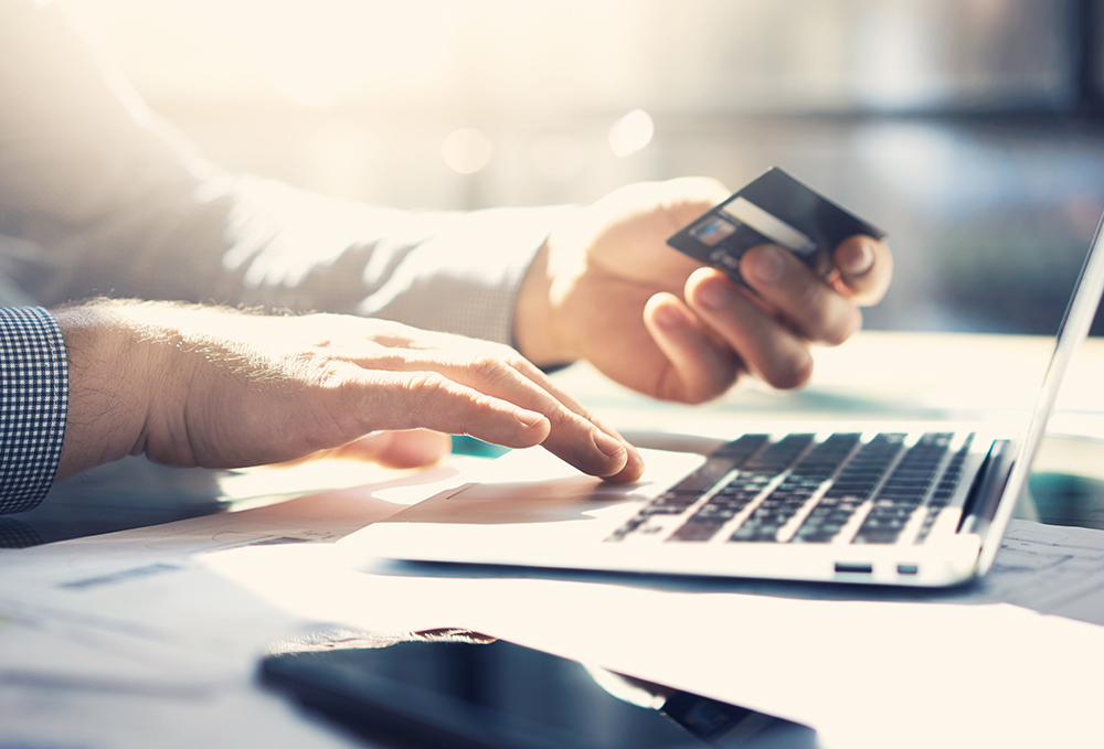 Man Holding Credit Card & Purchasing Language Services from a Professional Company
